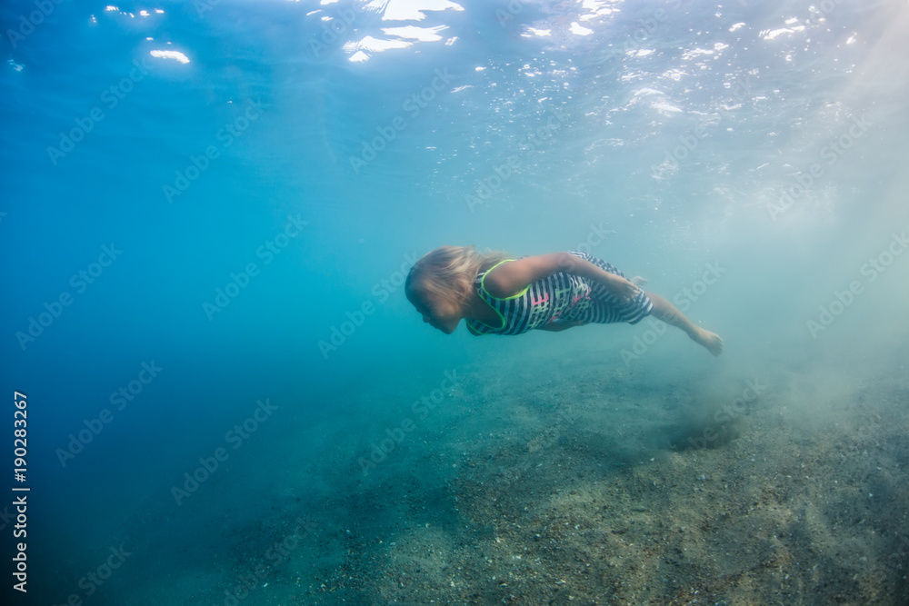little blonde girl in sea water underwater