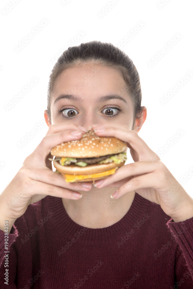 Adolescent girl enjoying a hamburger on a white background Adolescent girl enjoying a hamburger on a white background