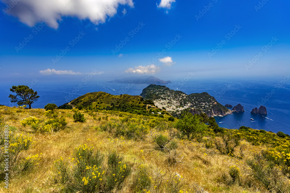 Italy. Capri Island. The main town Capri and easten part of island with Faraglioni (rock formation) seen from Monte Solaro. There is Sorrentine Peninsula in the background (on left)