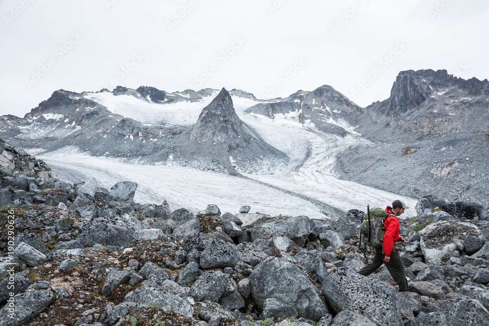 Fototapeta premium Hiker above Snowbird Glacier in Hatcher Pass area of Alaska, summer 2017.