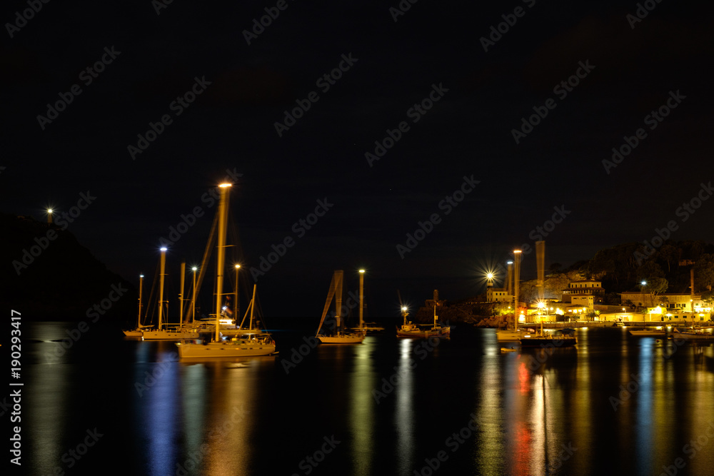 Boats swinging on the sea. Blurred mast. Night on the boats in bay.
