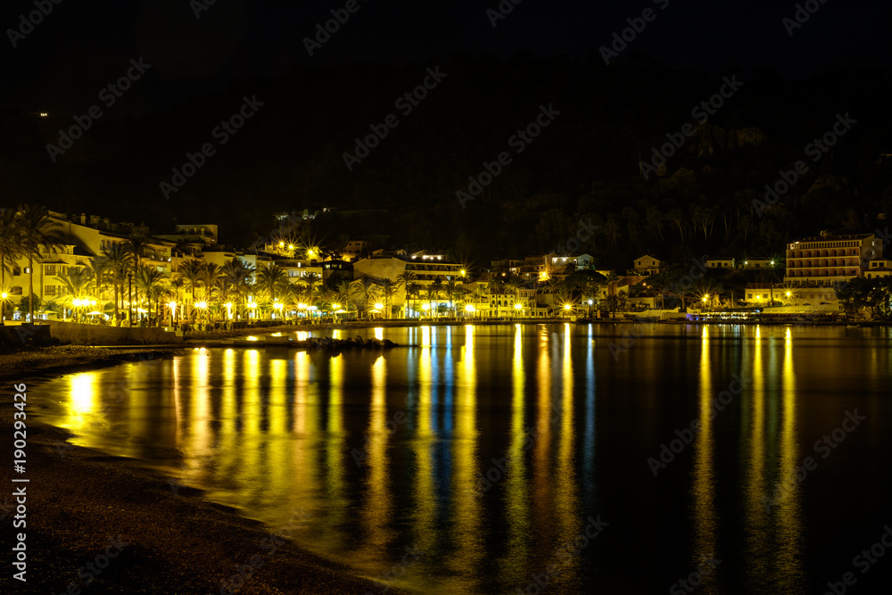  Mediterranean bay captured at night. Reflection of lights at sea. Yellow, blue, green. Palms. Hotels. Port de Soller, Mallorca.