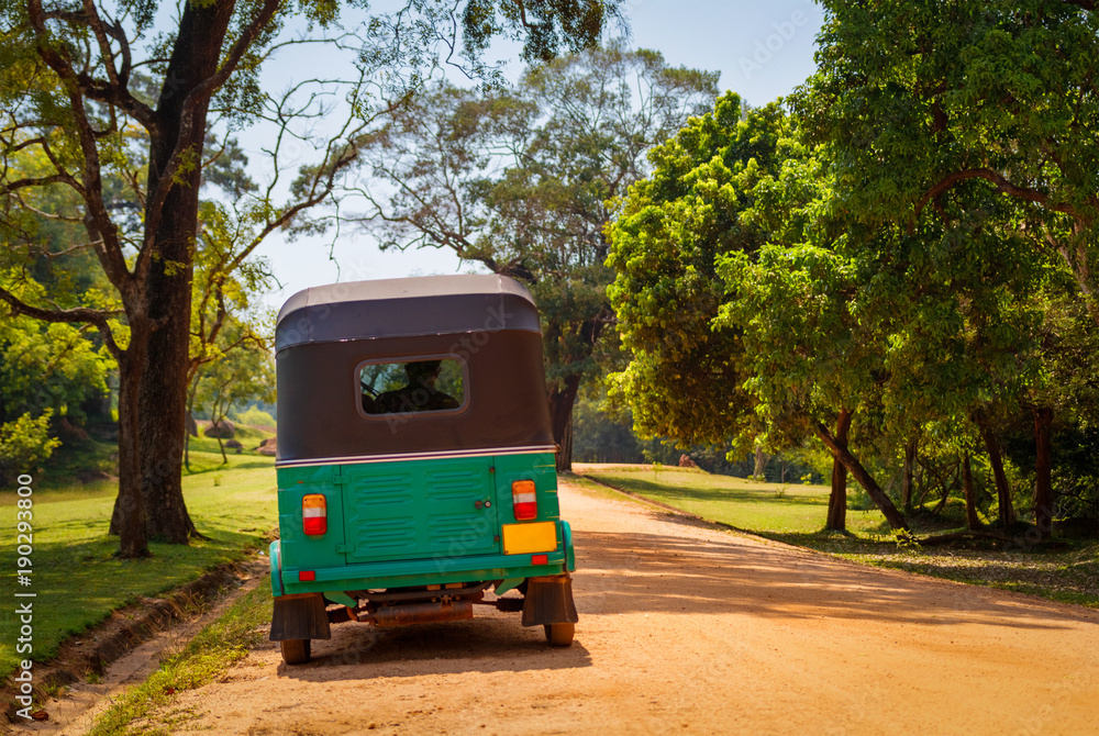 Green tuk tuk on the sand road, Sri Lanka