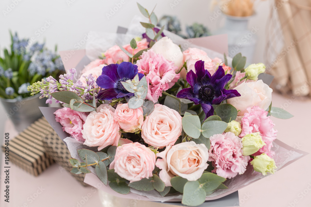 beautiful luxury bouquet of mixed flowers on pink table. the work of the florist at a flower shop.