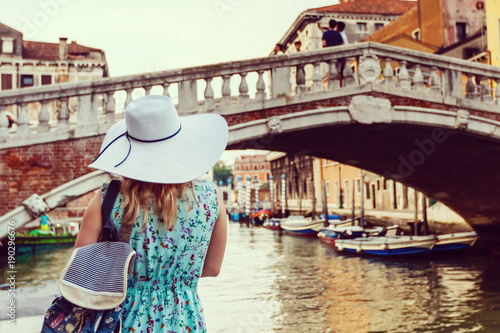 Travel tourist woman with backpack in Venice, Italy. girl on vacation smiling happy by Grand Canal. girl having fun traveling outdoors.
