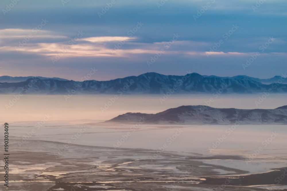 Interesting looking snow covered mountains of Utah in the afternoon just after a blizzard. The light coming into the plane window created an interesting array of colors. Interesting looking snow covered mountains of Utah in the afternoon just after a blizzard. The light coming into the plane window created an interesting array of colors.