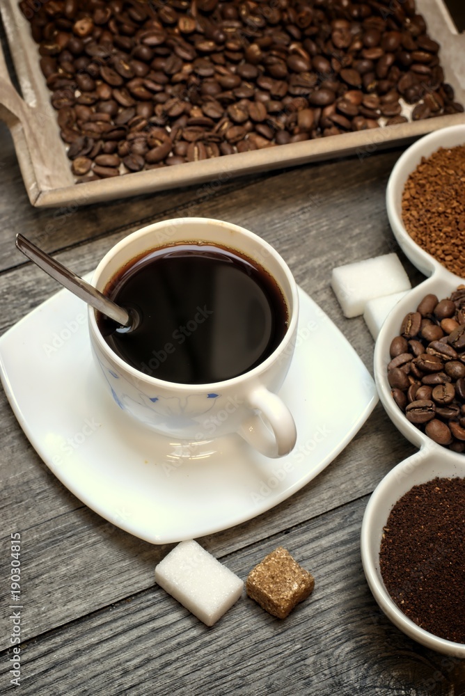 Fototapeta premium Drinks, drinking, energy and caffeine concept-coffee cups, coffee beans, ground coffee and instant on a wooden background.