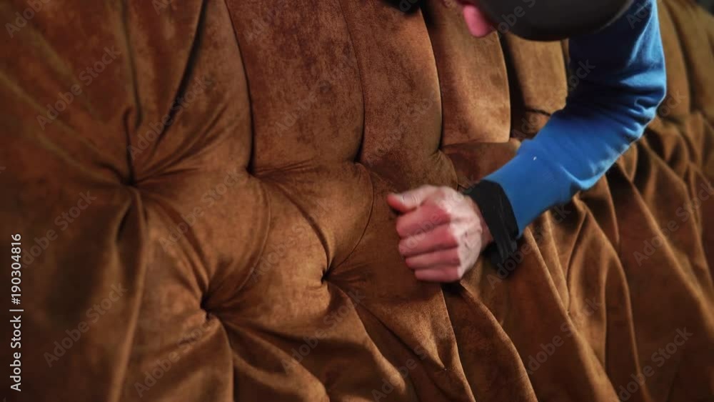 close up shot of the man's hands, who corrects the creases on the couch, persons made a sofa in the furniture factory, carpentry master touches the soft upholstery close up shot of the man's hands, who corrects the creases on the couch, persons made a sofa in the furniture factory, carpentry master touches the soft upholstery