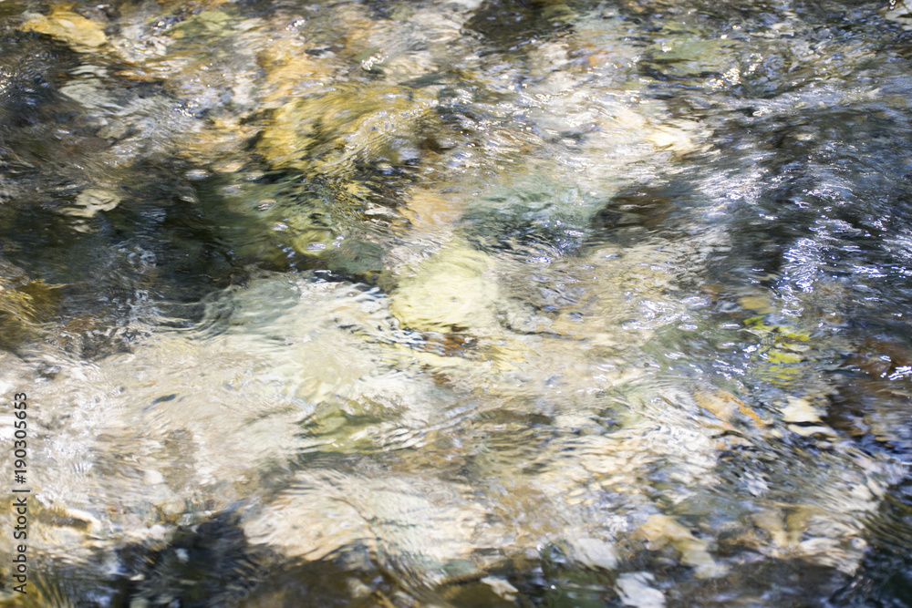 Fototapeta premium Water surface with rocks blurred