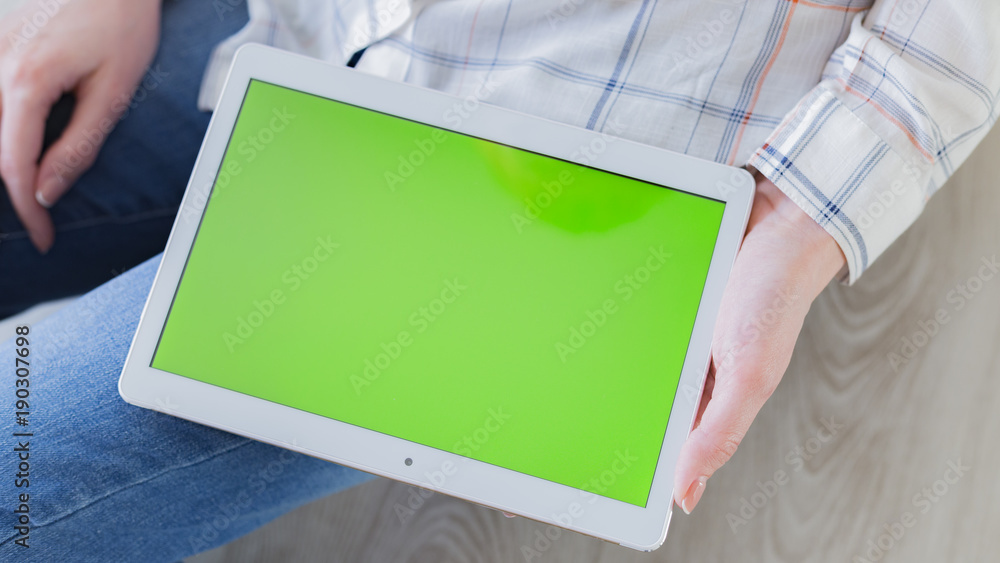 Woman at home relaxing reading on the tablet computer with pre-keyed green screen Woman at home relaxing reading on the tablet computer with pre-keyed green screen