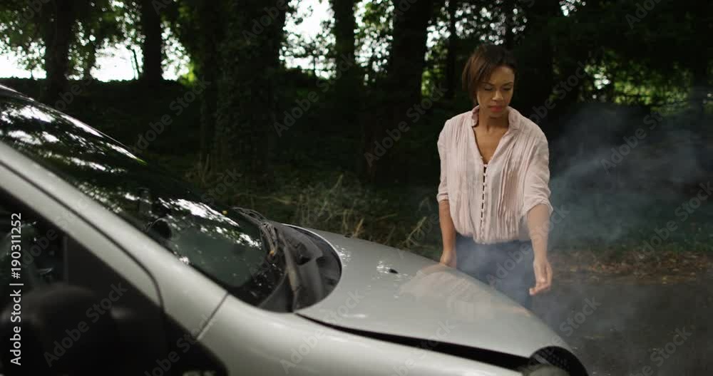 4k, Young African American woman walks to look under the hood of a broken down car. Slow motion. 4k, Young African American woman walks to look under the hood of a broken down car. Slow motion.