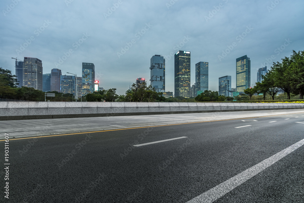 empty asphalt road with city skyline background in china. empty asphalt road with city skyline background in china.