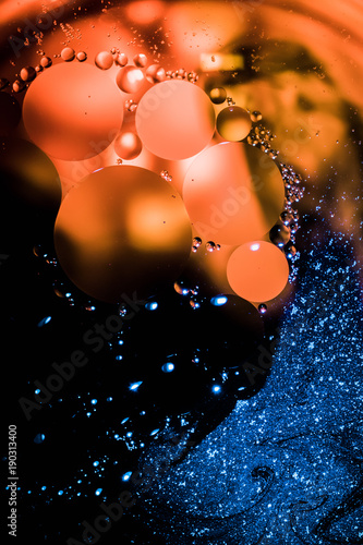 Abstract macro photo of oil in water using a high powered flashlight and blue and orange food coloring to make those oil circles really pop.