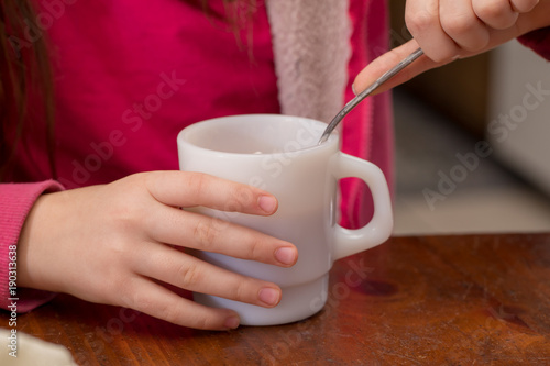 Girl with a spoon in a cup