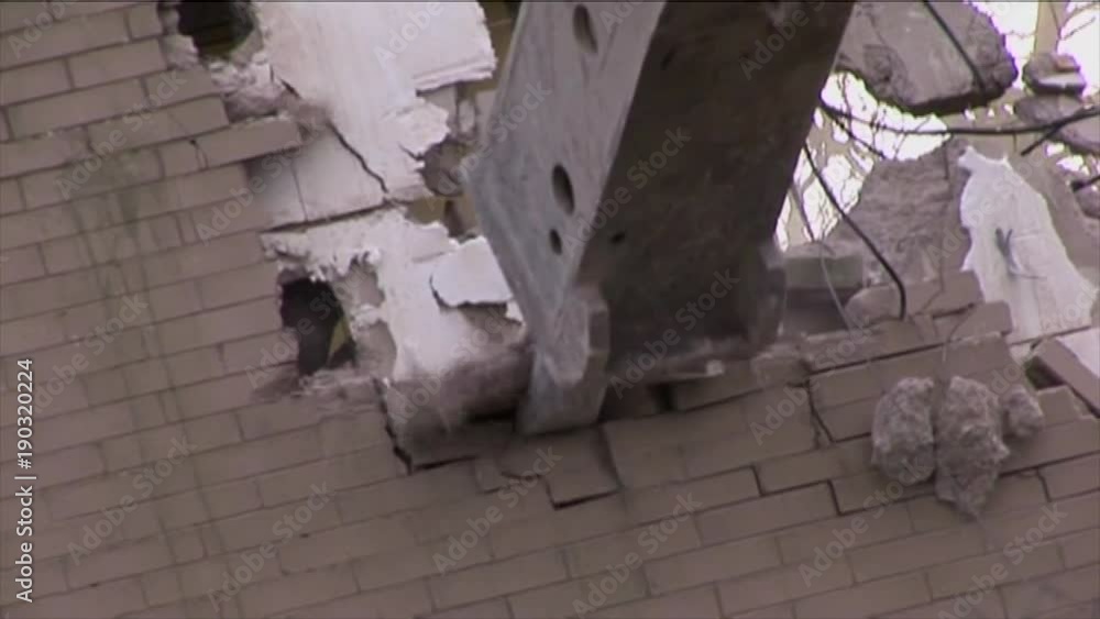 Demolition pusher arm punches through brick wall masonry Demolition pusher arm punches through brick wall masonry