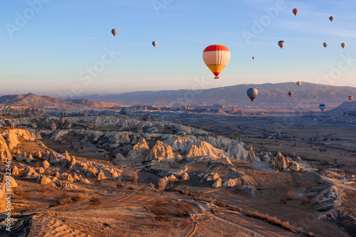 Many hot air balloons in the sky at sunrise on the background of mountains in Cappadocia Goreme, Turkey