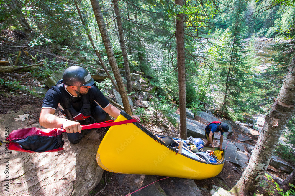 Portaging whitewater in canoes on the Noire River in Quebec, Canada.