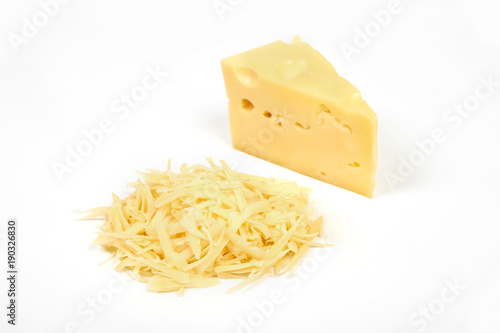 piece of cheese and heap of grated cheese, isolated on white background.