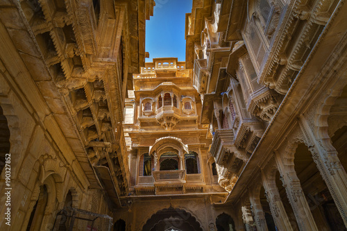 Rajasthan heritage building exterior made of yellow limestone with intricate artwork known as the Patwon ki haveli at Jaisalmer. photo