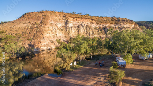 Fotografie Aerial view of caravan and four wheel drive vehicle camped next to a river pool