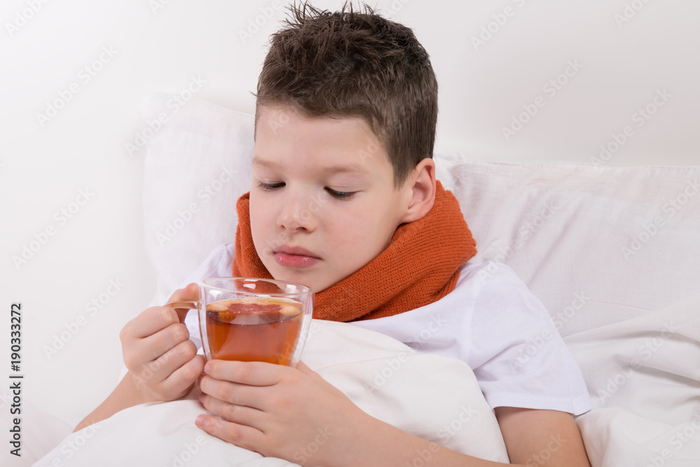 a boy with a sore throat, is treated with warm tea a boy with a sore throat, is treated with warm tea