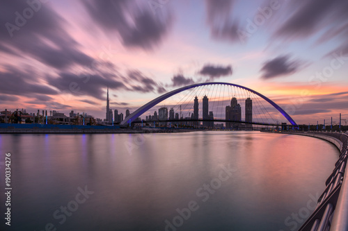 Fototapeta Naklejka Na Ścianę i Meble -  Long exposure of stunning sunrise colors over Dubai Downtown and Dubai Water Canal. Dubai, UAE.