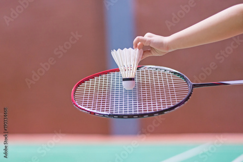 kid holding badminton racket and shuttlecock in badminton court