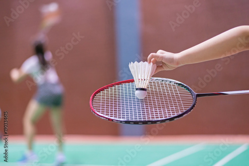 kid holding badminton racket and shuttlecock  in badminton court