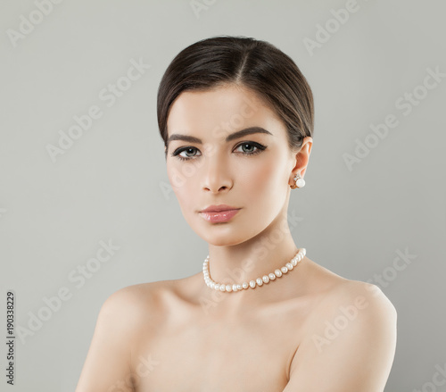 Elegantl Woman with Pearls Earrings and Necklace on Background