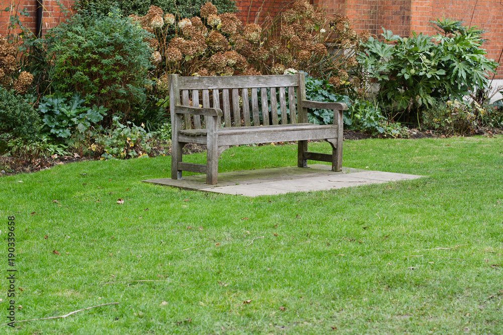 wooden bench on green grass in a park wooden bench on green grass in a park