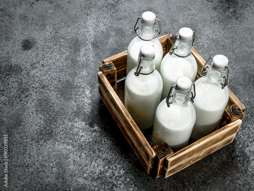 Fényképezés Bottles of fresh milk in an old box.