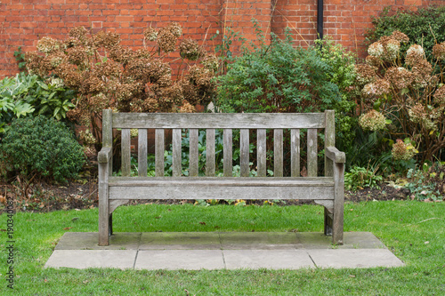 wooden bench on green grass in a park photo