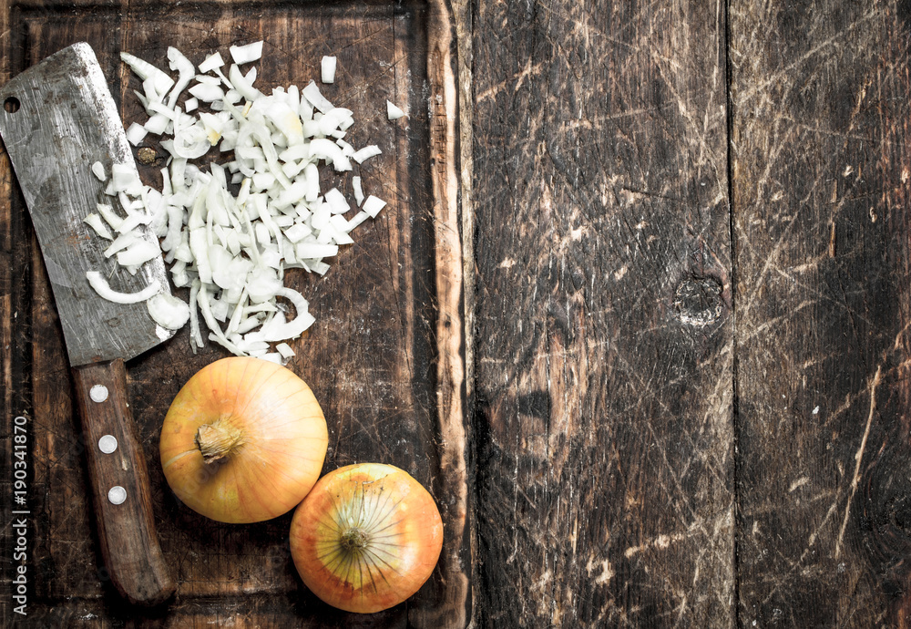 Fresh onion with old hatchet on a cutting board. Fresh onion with old hatchet on a cutting board.