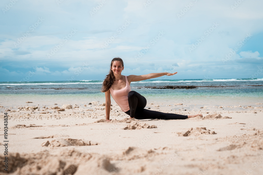 Woman training yoga on the beach
