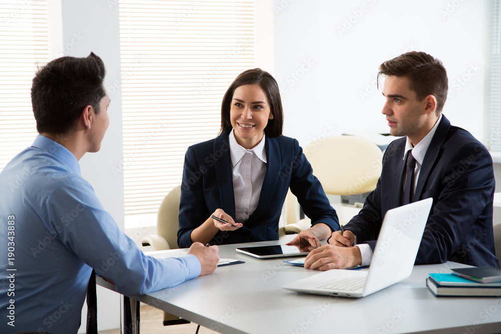 Businesswoman explains to businessmen a new project Businesswoman explains to businessmen a new project