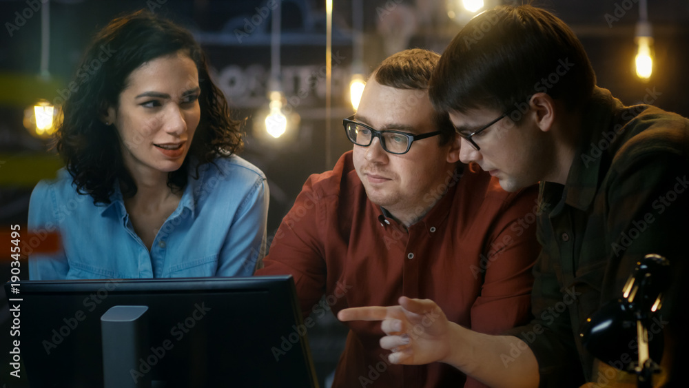 Three Office Employees Have Discussion about Ongoing Project, They Point at Personal Computer Screen. They Work in the Creative Office.