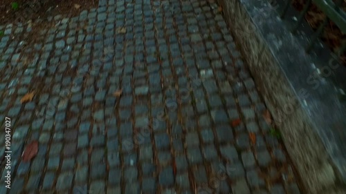 Walking on granite pavement. Grungy. Old. On the street.