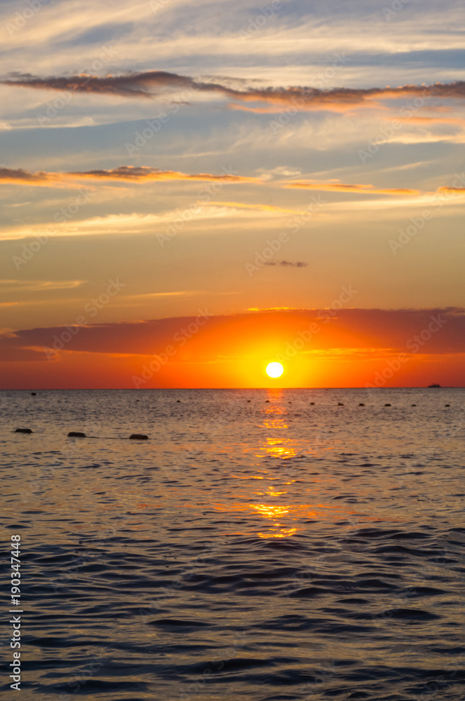 Fototapeta premium Amazing sea sunset, the sun, waves, clouds