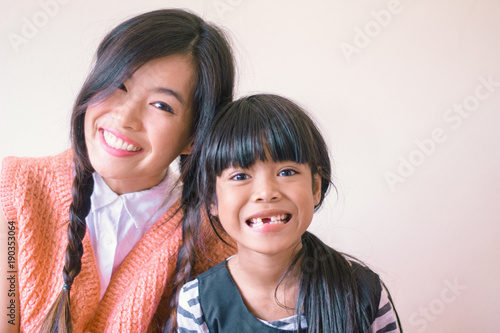 Sisterhood Concept - Two young asian girls smile 