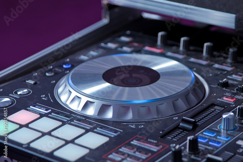 professional music equipment for playing and control music in nightclub with hands DJ . Dj mixes the track in the nightclub at party . Headphones in foreground and DJ hands in motion