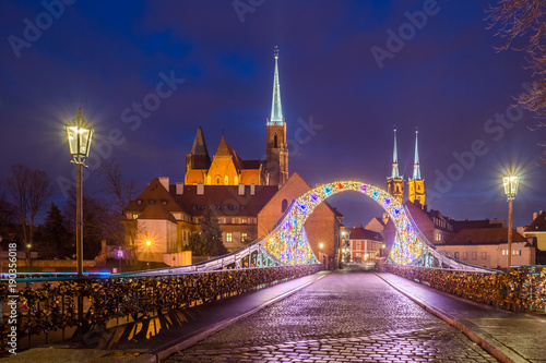 Tumski bridge and Holy Cross church at night in Wroclaw, Silesia, Poland