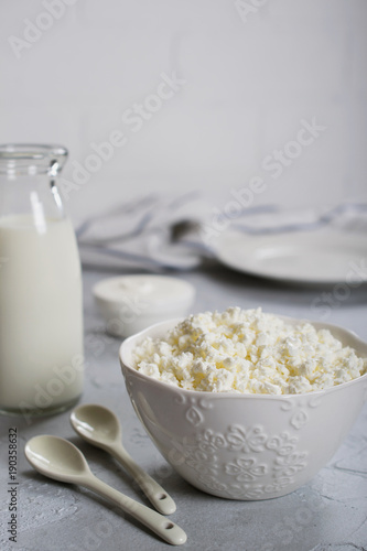 Organic Farming Cottage cheese, curd in a white ceramic bowl, sour cream and milk in a bottle