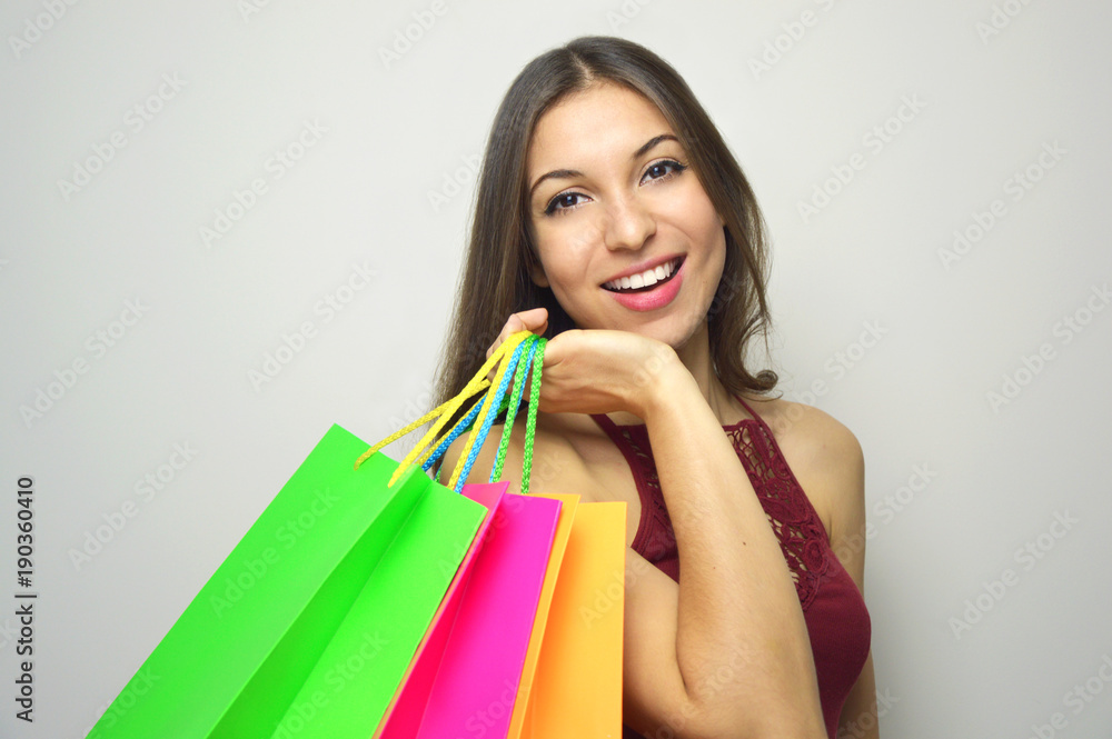 Happy smiling woman holdings shopper bags on gray background. Copy space.