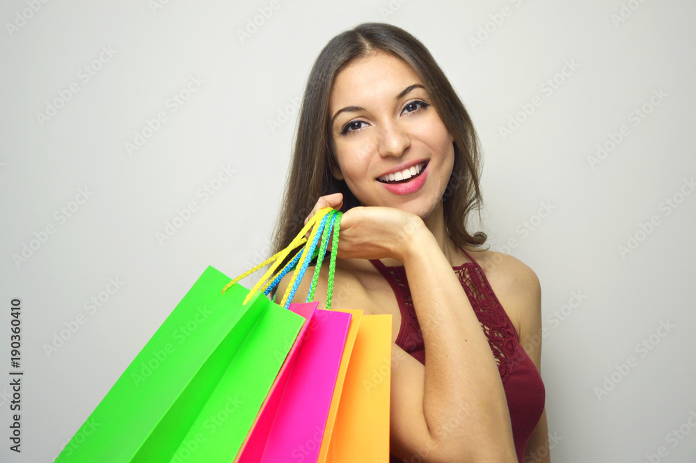 Happy smiling woman holdings shopper bags on gray background. Copy space. Happy smiling woman holdings shopper bags on gray background. Copy space.