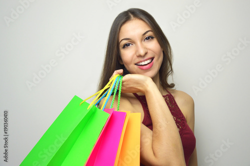 Happy smiling woman holdings shopper bags on gray background. Copy space.