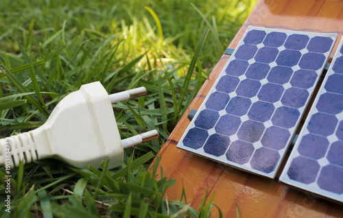 Solar panel on roof and power plug on the grass. Solar Energy Concept Image. 