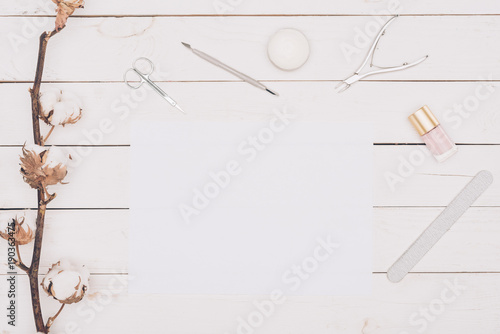 top view of manicure tools and white paper on wooden table