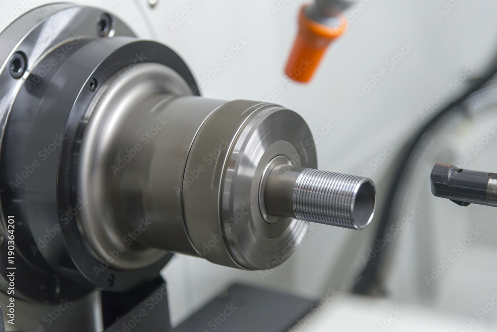 The CNC lathe machine cutting the thread at the end of the pipe.The water pipe manufacturing process. The CNC lathe machine cutting the thread at the end of the pipe.The water pipe manufacturing process.