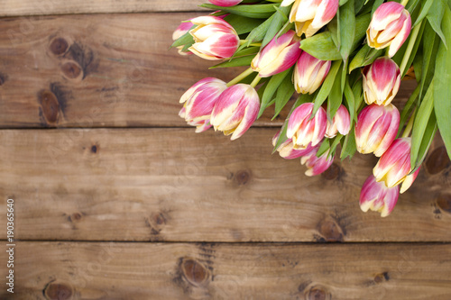 Beautiful bouquet of fresh spring flowers. Tulips. Wooden brown background. Free space for text or a postcard. © Marina