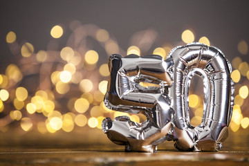 Silver number 50 celebration foil balloon against blurred light background